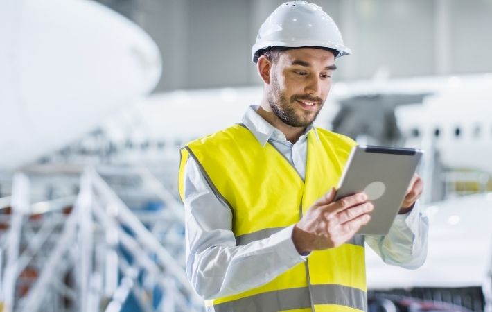 McKee service tech in high-vis vest and hardhatdoing walkthrough inspection with iPad