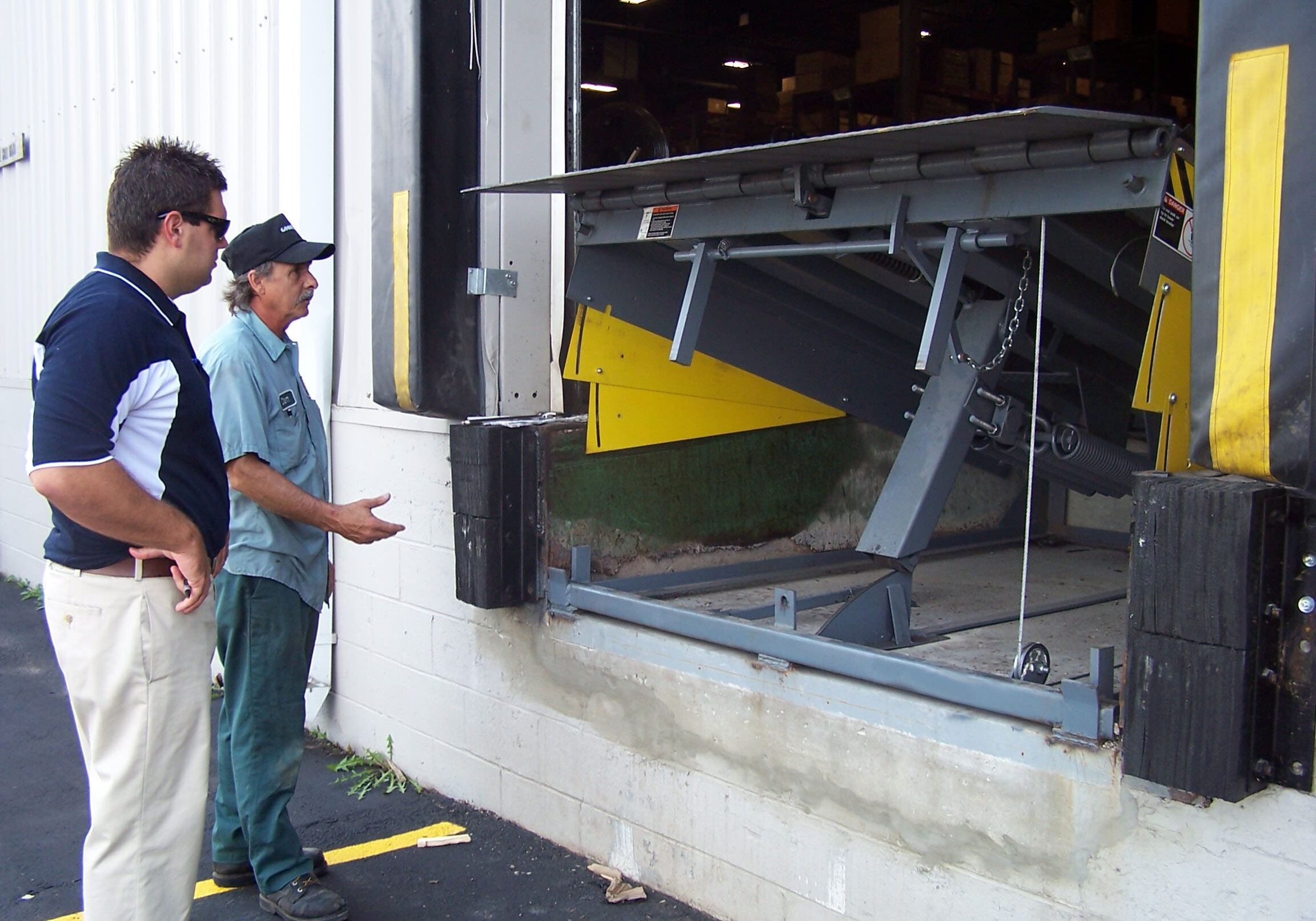 mckee dock leveler installation McKee service techs inspecting a loading dock leveler for an overhead door garage bay